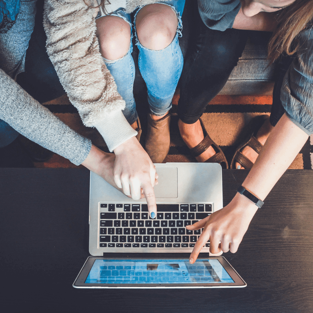 many people pointing on notebook screen